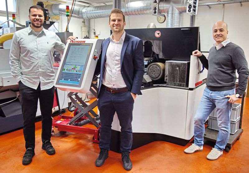 Die drei Verantwortlichen von Tschudin und Strähl Décolletage posieren vor der Tschudin «CUBE 350», die über einen bemerkenswert kleinen Footprint verfügt und somit wenig Platz in den Produktionshallen beansprucht. (Bild: Matthias Böhm)