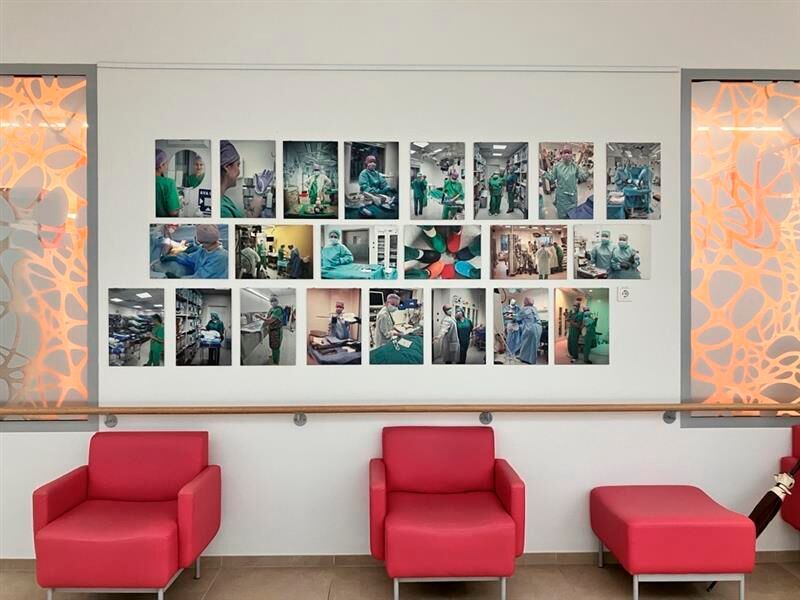 Das Krankenhaus ist sehr groß und weitläufig. Auf dem Weg zu den einzelnen Stationen werden wir von diversen Bildern begleitet: Fotografien an den Wänden erzählen von der Arbeit der Fachkräfte – sie geben tiefere Einblicke und zeigen etwa das OP-Geschehen jenseits der Kulissen.  (Bild: © Serina Sonsalla)