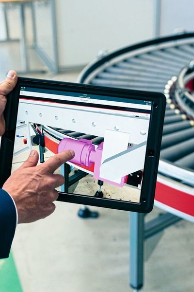 Mittels eines Industrie-Tablets lässt sich per Scan auf den Originalmotor – hier am Beispiel eines Rollenförderers – die 3D-CAD-Zeichnung der Maschine öffnen. Die Augmented-Reality-Anwendung sorgt dafür, dass die realen Objekte direkt mit den digitalen Darstellungen vereint werden.  (Tillmann Franzen)