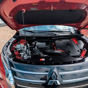 3. Das Antriebskonzept: Unter der Motorhaube des Mitsubishi Outlander ist ein 100 kW/136 PS starker 2,4-Liter-Benziner verbaut. In Kombination mit zwei E-Motoren an der Vorder- und Hinterachse, die für den Allradantrieb sorgen, liegt die Systemleistung bei 225 kW/306 PS. Für den Sprint von Null auf 100 km/h benötigt das Modell knapp acht Sekunden. Der Antrieb erwies sich auf den Testfahrten als harmonisch, kraftvoll und angenehm leise. (Bild:  Mauritz – VCG)