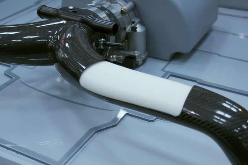 Stratasys bietet für frei geformte, holkörperartige Komponenten aus CFK die Möglichkeit an, die nötigen Kerne für den benötigten Hohlraum zu drucken, um die das CFK-Tape gewickelt werden kann. Nach dem Aushärten kann der 3D-gedruckte Kern ausgewaschen werden. Dieses Beispiel ist im Heck eines Porsche 911 integriert. (Bild: Königsreuther)