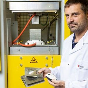 At 150 tons of pressure, the cellulose fibers are first dewatered and then consolidated in a second operation. Thomas Geiger in front of his special press.(Source:  Empa)