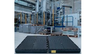 Die beiden schwarzen Bauteile vor dieser Wickert-Presse haben bewiesen, dass man leichte Batteriegehäuse für die E-Mobilität wirtschaftlich auch aus faserverstärkten Thermoplasten herstellen kann. Das brachte dem Team der TU Chemnitz den JEC Innovation Award 2026 ein. (Bild: TU Chemnitz)