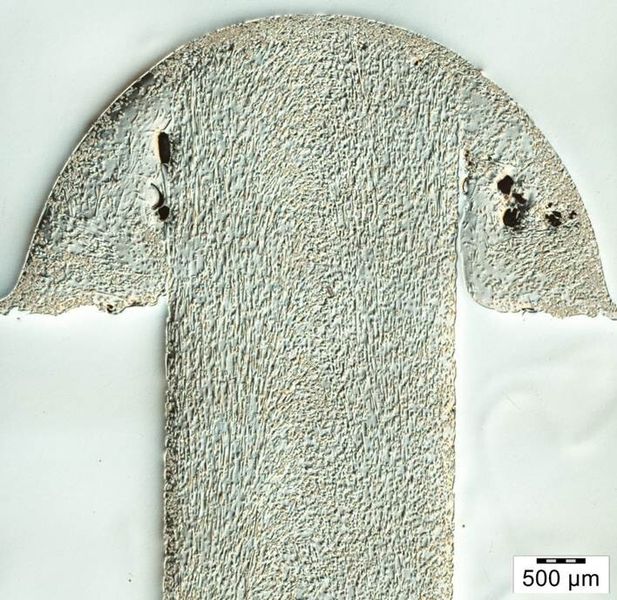 Typischer Nietkopf (DVS lang) erzeugt mit dem Warmumformverfahren. Die Anbindung des geschmolzenen Materials zum Schaft ist unvollständig.  (bdtronic)