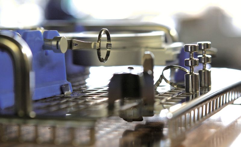 Bild 1: Kleine, dünnwandige Bauteile in höchster Präzision mit Laser- und Wasserstrahl-Feinschneiden fertigen: Edelstahlkomponenten eines Ophthalmomikroskops, ein Edelstahlträgersystem und Silikonfixierelemente (blau). (Bild: LK Mechanik)