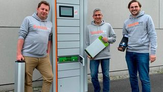 Die Geschäftsführung des Battery-as-a-Service-(BaaS-)Pioniers Swobbee mit diversen Akkus vor einer Wechselstation. (Swobbee)