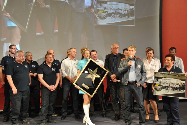 Die Mannschaft der Bulli-Werkstatt mit ihrem Chef Harald Schomburg (mit Mikro) bei der offiziellen Einweihungsparty. (Foto: Dominsky)