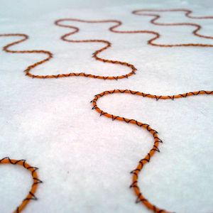 Längst ein Wärme-Klassiker: Solche isolierten Kupferdrähte für Auto-Sitzheizungen werden zumeist per Drahtlegetechnik auf Textilmaschinen befestigt.(Bild:  Tajima)