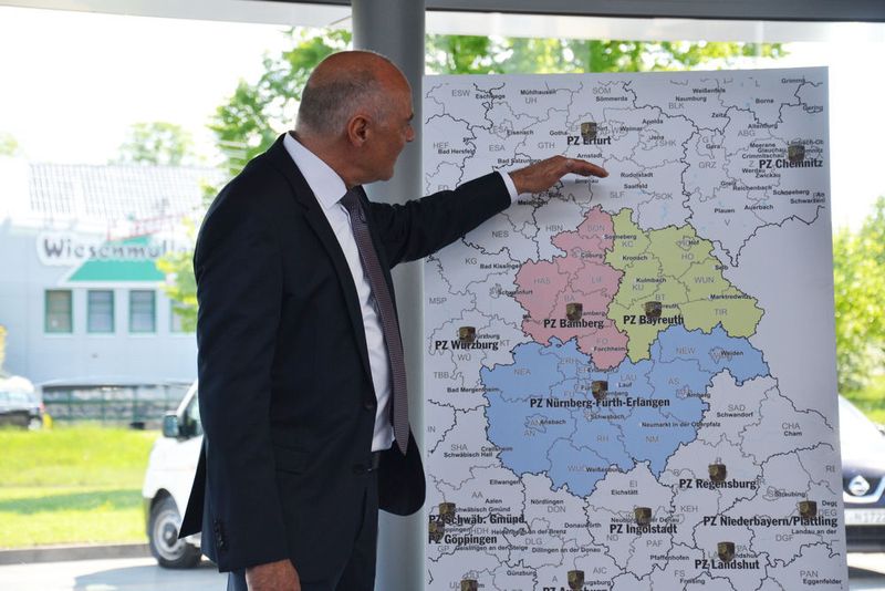 Michael Eidenmüller zeigt auf der Landkarte, wie groß das Porsche-Marktverantwortungsgebiet seiner Autohausgruppe mittlerweile geworden ist. (Michel/»kfz-betrieb«)