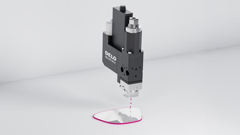 Jetventil Delo-Dot PN5 trägt die Kantenbeschichtung berührungslos und präzise auf eine AR-Glaskante auf; Beschichtung zur besseren Illustration in magenta dargestellt. (Bild:  Delo)
