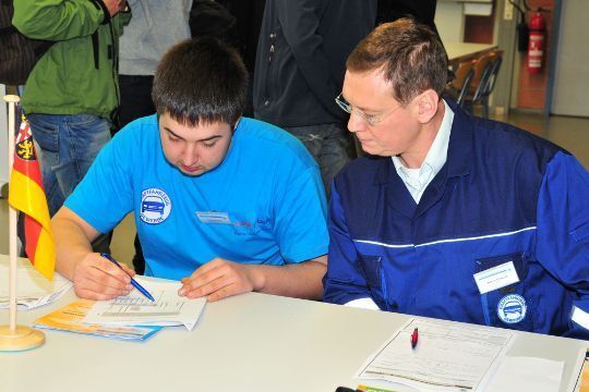 Daniel Wagner aus Rheinland-Pfalz erläutert dem Prüfer seine Messpunkte auf dem Stromlaufplan. (Schmidt)