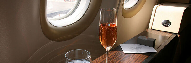 9. Feiern Sie Ihren Urlaubsbeginn. Zum Beispiel, indem Sie im Flugzeug ein Gläschen Sekt trinken.  (chrischuster - stock.adobe.com)