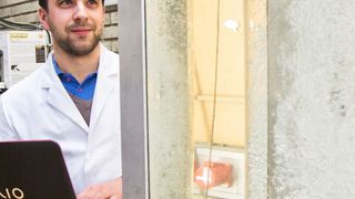 Christian Witz vom Institut für Prozess- und Partikeltechnik der TU Graz bei der Arbeit, vor einem Plexiglas-Modell eines gerührten und begasten (Bio-)Reaktors  . (TU Graz)