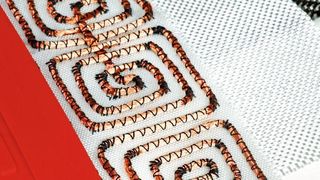 Die Heizmatte besteht aus einer Induktionsspule, die auf ein Kunststoffgewebe gestickt ist und einer Vakuummatte aus Silikon.  (DLR)