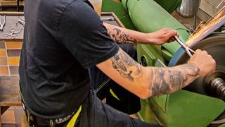 Die Auszubildenden der Tuttlinger Berufsschule erlernen viele unterschiedliche Verfahren der Oberflächenbearbeitung, darunter auch das Schleifen an der Bandschleifmaschine. Mit dem Esta-Nassabscheider können die anfallenden Schleifstäube und Funkenflug mittels Wasserabscheidetechnologie schnell unschädlich gemacht werden. (Bild: Esta)