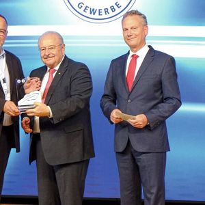 Einen Sonder-Kalligraphen überreichte ZDK-Präsident Jürgen Karpinski (M.) und ZDK-Vorstand Arne Joswig (r.) an Michael Neuburger, Pressesprecher der Innung Gifhorn, für sein Projekt „Werkstatthilfe für Geflüchtete aus der Ukraine“. (Bild:  Zietz – »kfz-betrieb«)