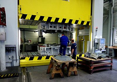 Ein fertig umgeformtes Bauteil wird aus dem Werkzeug entnommen. (Archiv: Vogel Business Media)