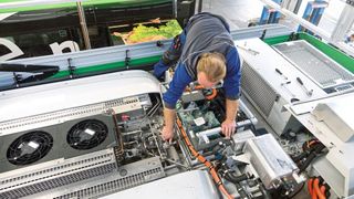 Statt im Motorraum und an weiteren Stellen ist eine CO2-Klimaanlage (bzw. Wärmepumpe) bei Bussen als kompakte Einheit auf dem Fahrzeugdach platziert. Die beiden Ventile des Klimaservicegeräts schließt der Mechaniker an den beiden Kreisläufen (Hoch- und Niederdruck) an. (Bild: Dominsky/»kfz-betrieb«)