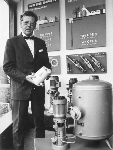 1958: Poul Due Jensen, der Unternehmensgründer von Grundfos; in den Händen hält er die erste Heizungsumwälzpumpe VP32, im Hintergrund und rechts im Bild sind mehrstufige CP-Pumpen in Segment-Bauweise zu sehen (Grundfos)