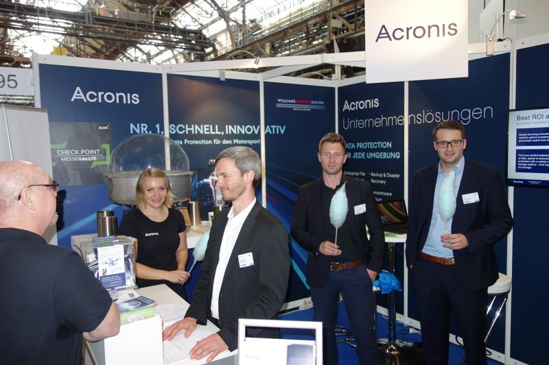 Arbeitsaufteilung, Marcel Henker, Acronis, arbeitet, Dimitri Schewtschenko, Acronis, und Fabian Franke, ALSO, genießen Zuckerwatte. (Bild: IT-BUSINESS)