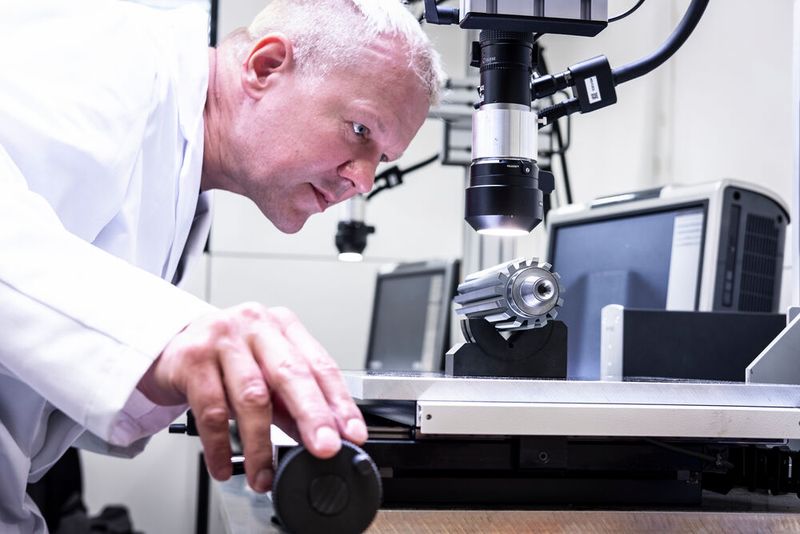 Hier hat ein Experte die Kantenradien eines Verzahnungswerkzeugs voll im Prüferblick. Laut Oerlikon Balzers ist es dabei nicht trivial, von Produkt zu Produkt, vergleichbare Ergebnisse zu erhalten. Das Nassstrahlen der Werkzeuge kann aber helfen. (Bild: P. Fuchs / Oerlikon Balzers)