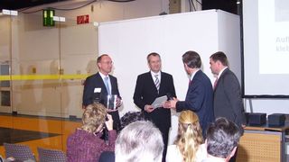 von links: Jan Kolmann, Leiter Team Technik bei Titgemeyer und Ludger Aschoff, Geschäftsführer von MKG in Lotte, erhalten den Preis aus den Händen von Ministerialdirigent Dr. Jäkel. (Archiv: Vogel Business Media)