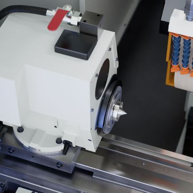 Das ist der kompakte Werkstück-Spindelstock mit Kegelrollenlagern, die eine exakte Rundheit im Bereich von 0,5 Mikrometern garantieren, so Emag. Weil der Schwenkbereich von 0 bis 30° reicht, kann man viele Schleifstrategien verfolgen. (Bild: Emag)