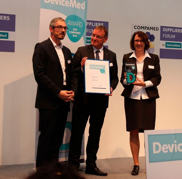 Jörg Warrelmann (Mitte), Sales Director Medical Europe der BU Lighting and Imaging von Schott, nimmt auf der Compamed 2016 gemeinsam mit Kollegin Karen Holst den Devicemed Award in der Kategorie „Medtech Pioneer“ entgegen. (Schäfer / Devicemed)