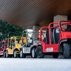In Bonbonfarben lackiert, steht der Mini Moke neben Luxuslimousinen und Supersportwagen als Strandshuttle vor den Designhotels.(Bild:  BMW)