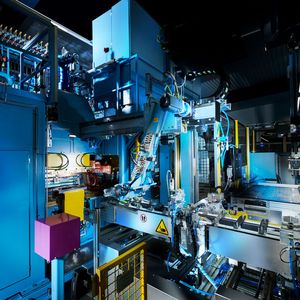 Über diese Zuführung erfolgt der Transport der drei aufeinandergelegten Bleche für eine Motorsägen-Führungsschiene in die Buckelpresse. Letztere sorgt für deren sichere und gleichmäßige Verbindung über viele Schweißbuckel, die dabei per Stromdurchfluss aufgeschmolzen werden.(Bild:  Nimak)