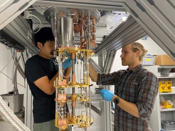 Jesse Zhang (l.) und Paul Wegmann stellen die Verkabelung des Detektors im Kühlaggregat fertig (Bild: Anna Soter / ETH Zürich)