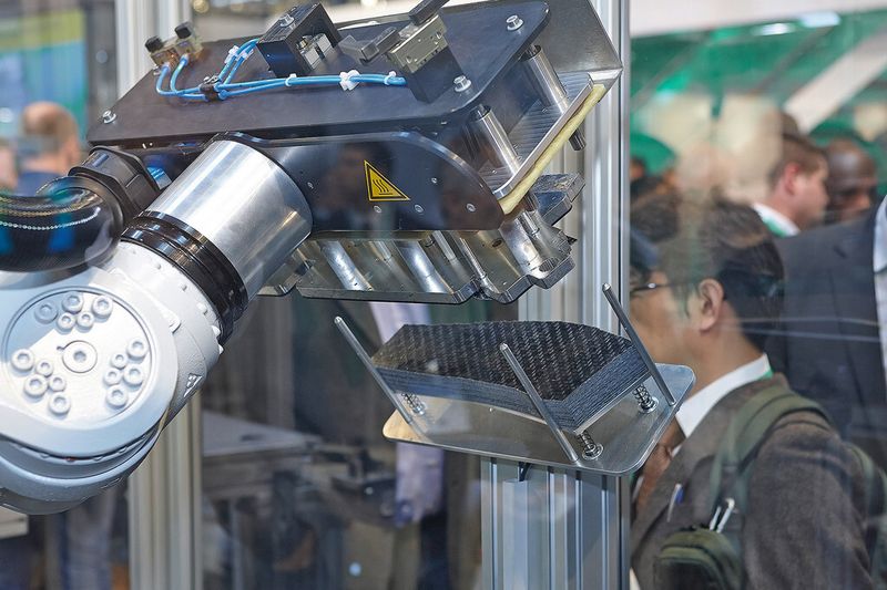 Die Greiferplatte des Sechs-Achs-Roboters ist so ausgeführt, dass sie die Organobleche nach ihrer Aufnahme bereits vorwärmt. (Bild: Arburg)