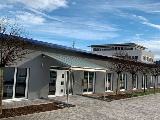 Eingang zum neuen Technikum der Michael Koch GmbH, im Hintergrund das „Fabrikle“.(Bild:  Michael Koch)