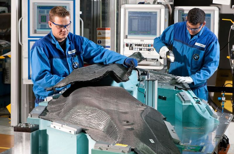 BMW Werk Landshut: Innovations- und Produktionszentrum CFK - Mitarbeiter konfektionieren Preforms, aus denen ein BMW i8 Seitenrahmen entsteht. (BMW Group)