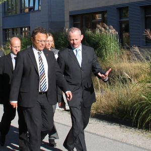 Der Bundesminister des Innern, Dr. Hans-Peter Friedrich (links), und Peter Bauer, Vorstandsvorsitzender der Infineon Technologies AG, am Unternehmenssitz von Infineon in Neubiberg bei München auf dem Weg zu Infineons Sicherheitslabors.