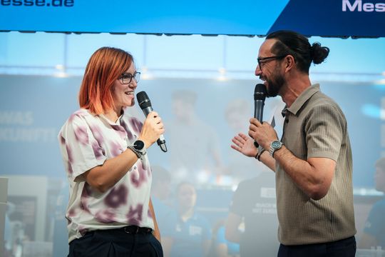 Kati Wilhelm, dreifache Olympiasiegerin und fünfmalige Weltmeisterin im Biathlon, und Moderator Hannes Hoch im Gespräch über Präzision im Hochleistungssport Biathlon.(Bild:  Thomas Wagner / Messe Stuttgart)