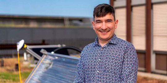 Pioneer Fellow Luca Thommen. Im Hintergrund der von ihm entwickelte Solarthermie-Kollektor 'SolarHeat'.(Bild:  Michel Büchel, ETH Zürich)