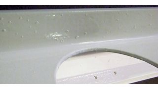 Bild 1: Pusteln auf einem lackierten Bauteil. Sie können auftreten, wenn das feuerverzinkte Bauteil nach dem Einbrennen der Grundierung noch mit einem Decklack versehen wird. (Bader-Pulver)