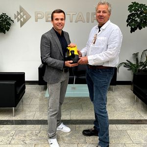 Andreas Kämpf übergibt die Marketingleitung bei Pentair Jung Pumpen symbolisch mit einer U3K-Pumpe an seinen Nachfolger Gunnar Wippersteg.(Bild:  Jung Pumpen)