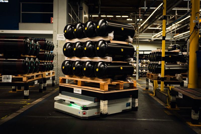 With centimeter precision, the KMP 1500P delivers 100-liter compressed air tanks to a welding station. (Image:Kuka)