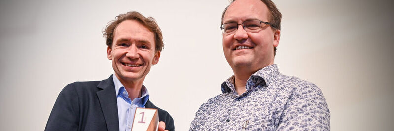 Dr. Ekkehart Jenetzky und Dr. David Martin nehmen den Innovationspreis für die „Fieber-App“ entgegen