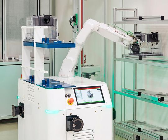 Der mobile Hero Fab 200 positioniert einen Waferbehälter millimetergenau in einem Reinraumregal – ein Beispiel für das zuverlässige Materialhandling in gewachsenen 200-mm-Fabriken.(Bild:  Fabmatics/Sven Claus)