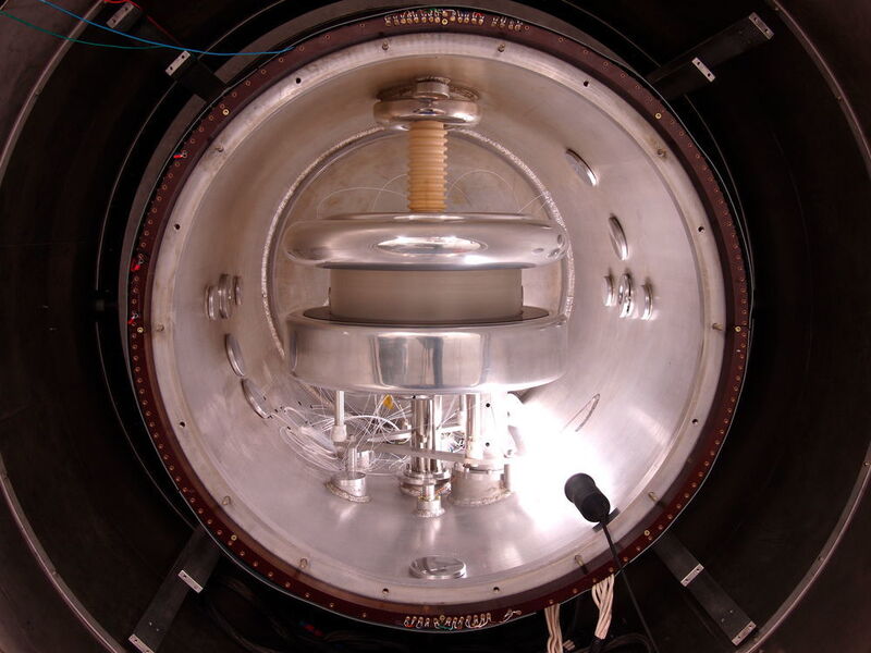 Blick ins Spektrometer, das das elektrische Dipolmoment der Neutronen vermisst. Der Durchmesser des silbernen Aluminiumtanks beträgt einen Meter. Aussen herum befindet sich im dunklen Bereich ein Magnetschild, dass das Erdmagnetfeld um den Faktor 10.000 abschwächt. (Bild: PSI/Zema Chowdhuri)