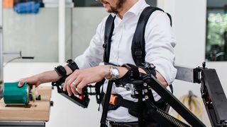 Moritz Hämmerle, Leiter Competence Team Production Excellence am Fraunhofer IAO, testet das Exoskelett in der Modellfabrik. (Bild: Ludmilla Parsyak/Fraunhofer IAO)