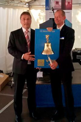 Bei der offiziellen Eröffnungsfeier in Offenbach übergab Niedziella symbolisch eine historische Brandschutz-Alarmglocke an Detlef Staemmler, Leiter des neuen Brandprüfzentrums. (S. Häuslein/konstruktionspraxis)