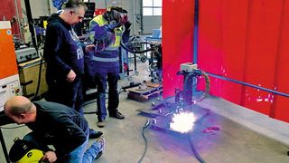 Mitarbeiter von DIN Tools und Smulders testen den Prototypen des Schweißroboters. (Igus)