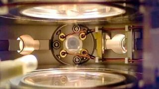 Blick in die Hauptvakuumkamer des NaK-Molekülexperiments. In der Mitte werden vier Hochspannungskupferdrähte zu einer Ultrahochvakuum-Glasküvette geführt, in der die ultrakalten polaren Moleküle erzeugt wurden. (Bild: MPQ )