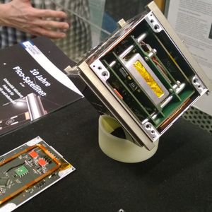 Modular aufgebaut: UWE-3 (r.) beherbergt mehrere Subsysteme, die auf einer Backplane aufgesteckt sind. Links im Bild ist eine der Magnetmomentspule zu sehen, die auf der Rückseite der Außenflächen angebracht sind. Mit ihrer Hilfe richtet sich der Kleinstsatellit am Magnetfeld der Erde aus.