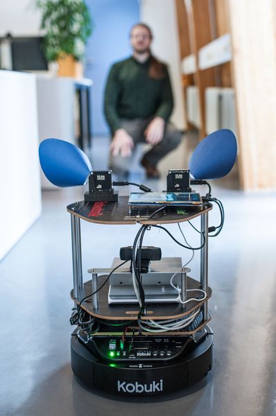 Der kleine Ninja Turtle Roboter nähert sich vorsichtig einem Wissenschaftler aus dem Projektteam. Er soll sich weder durch Nebengeräusche noch Sichthindernisse irritieren oder ablenken lassen und nur relevante Informationen verarbeiten - wie ein menschliches Gehirn. (Universität Ulm/Elvira Eberhardt)