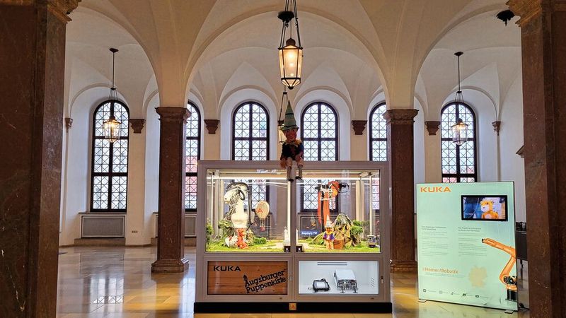 Bis Ende Januar 2024 sind die Roboter "Mario" und "Nette" als Puppenspieler im Erdgeschoss des Augsburger Rathauses zu sehen.  (Bild:  Kuka Group)